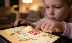 A child taps the retry button in Angry Birds, illustrating what kids learn from Angry Birds about building resilience after failure.